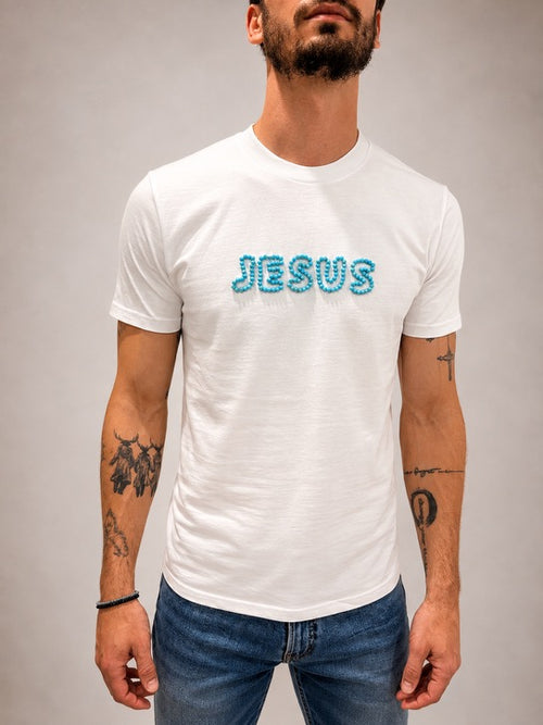 Close-up of White JESUS t-shirt with hand-beaded aqua blue lettering