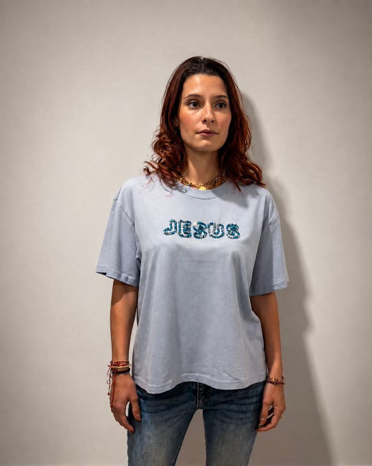 Woman wearing relaxed-fit oversized Powder Blue hand-beaded JESUS tee