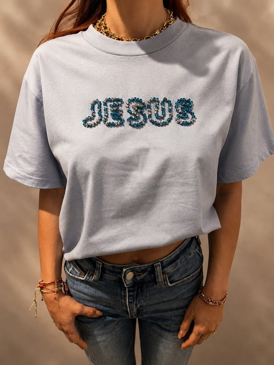 Close-up of oversized Powder Blue JESUS t-shirt with hand-beaded blue and silver lettering