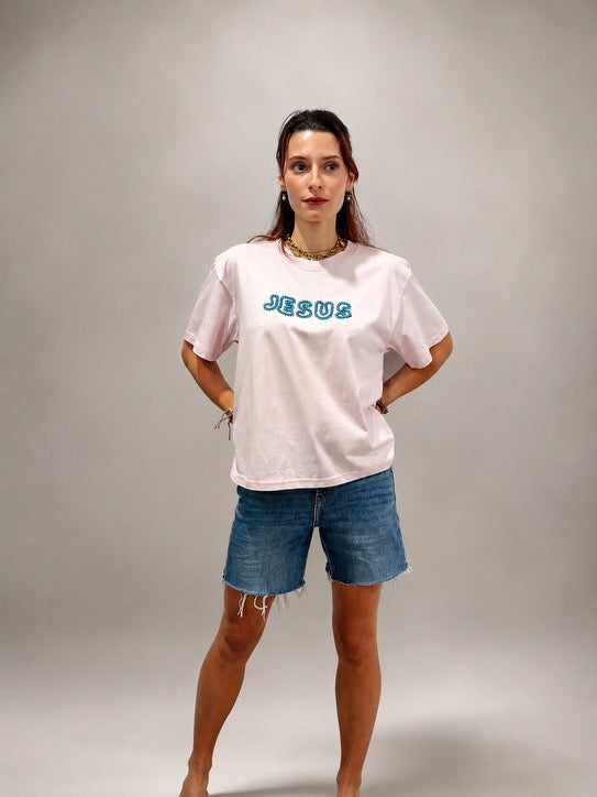Woman wearing oversized Lilac JESUS t-shirt with hand-beaded aqua blue lettering