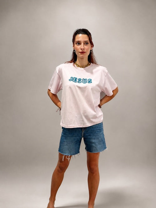 Woman wearing oversized Lilac JESUS t-shirt with hand-beaded aqua blue lettering