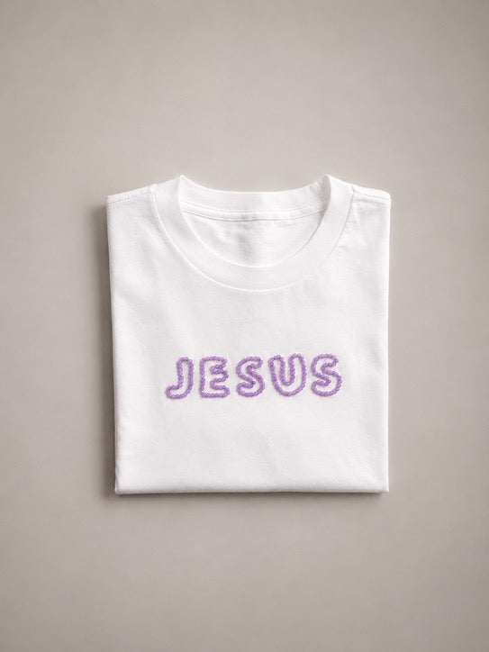 Folded oversized White t-shirt with hand-beaded lilac JESUS lettering